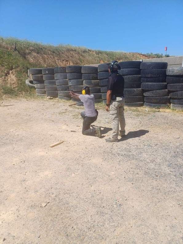 Instructor supervising a student on the pistol range